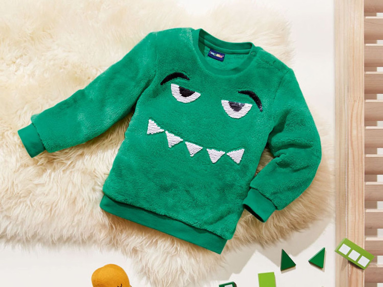 Grüner Pullover mit Monstergesicht für Kinder.