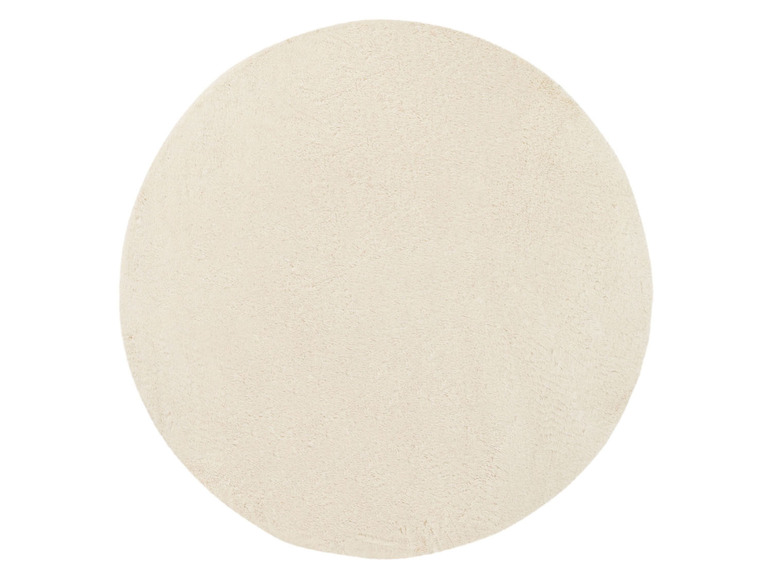 Ein runder, cremefarbener Teppich.
