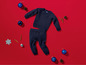 Ein blauer Pullover und eine Hose für Babys mit Weihnachtsdekoration.