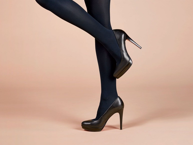 Schwarze Pumps und Strümpfe auf beigen Hintergrund.