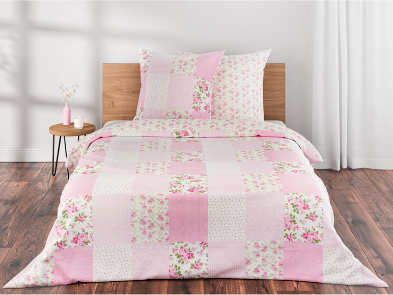 Ein rosa Bettüberwurf mit Blumenmuster im Patchwork-Stil.