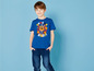 Junge in einem blauen T-Shirt mit Paw Patrol-Druck und blauen Jeans.