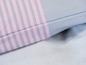 Eine rosa-graue gestreifte Bettdecke.
