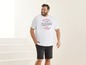 Mann in einem weißen T-Shirt mit dem Aufdruck 'The Vintage Original' und schwarzen Shorts.
