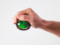Eine Hand hält eine grüne Handtrainer-Kugel.