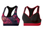 Zwei Sport-BHs: einer mit rosa-blauem Muster und einer schwarzen mit roten Akzenten.