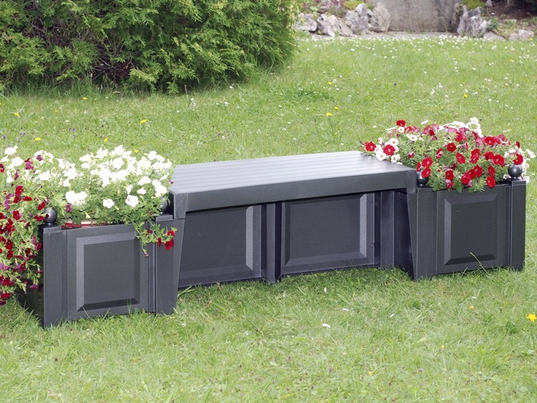 Eine schwarze Gartenbank aus Holz mit passenden Blumenkästen, gefüllt mit Blumen.