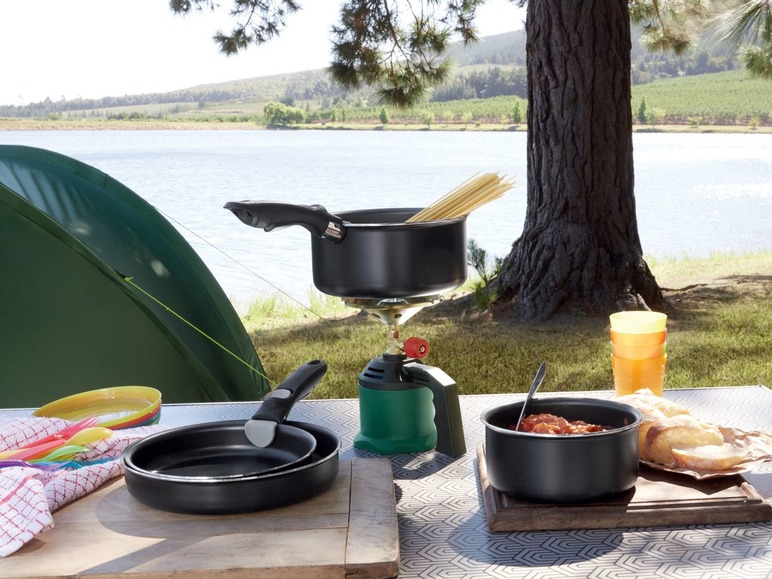 Campingausrüstung, darunter ein Topf auf einem Gaskocher und eine Bratpfanne.