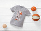 Ein graues T-Shirt mit Basketball-Motiv und drei Basketbälle.
