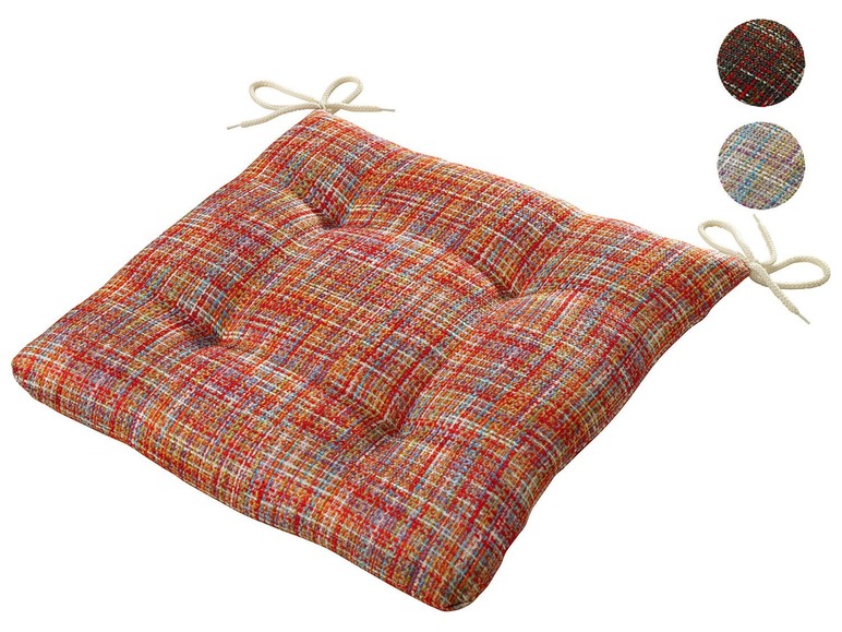 Ein rotes Kissen mit Blumenmuster und Bindebändern.