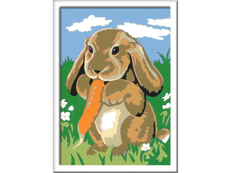 Ein süßes Kaninchen frisst eine Karotte auf einer Wiese.