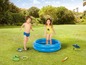 Zwei Kinder spielen mit einem aufblasbaren Pool und Wasserspielzeug im Garten.