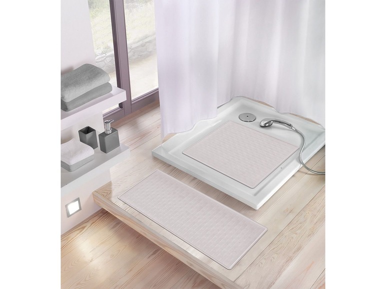 Zwei Badezimmermatten, eine in der Dusche und eine auf dem Boden.