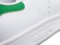 Weiße Adidas Stan Smith Sneaker mit grünen Akzenten.