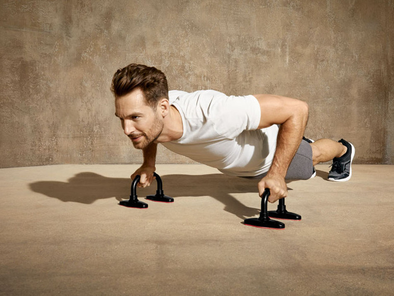 Ein Mann macht Liegestütze mit Push-up-Griffen.