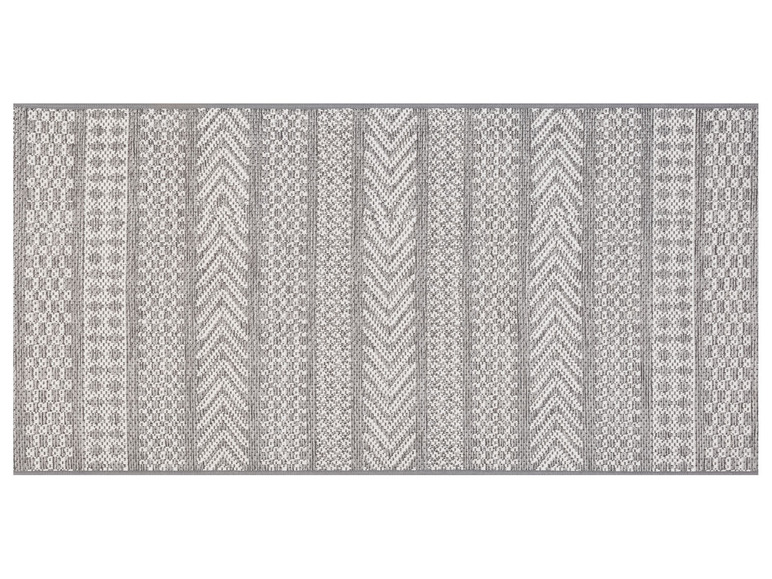 Ein weißer und grauer geometrischer Teppich mit verschiedenen Mustern.