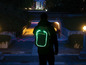 Eine Person trägt einen Rucksack mit LED-Beleuchtung in der Dunkelheit.