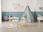 Ein Kinderzimmer mit einem Tipi-Zelt, einem Tisch und Stühlen.