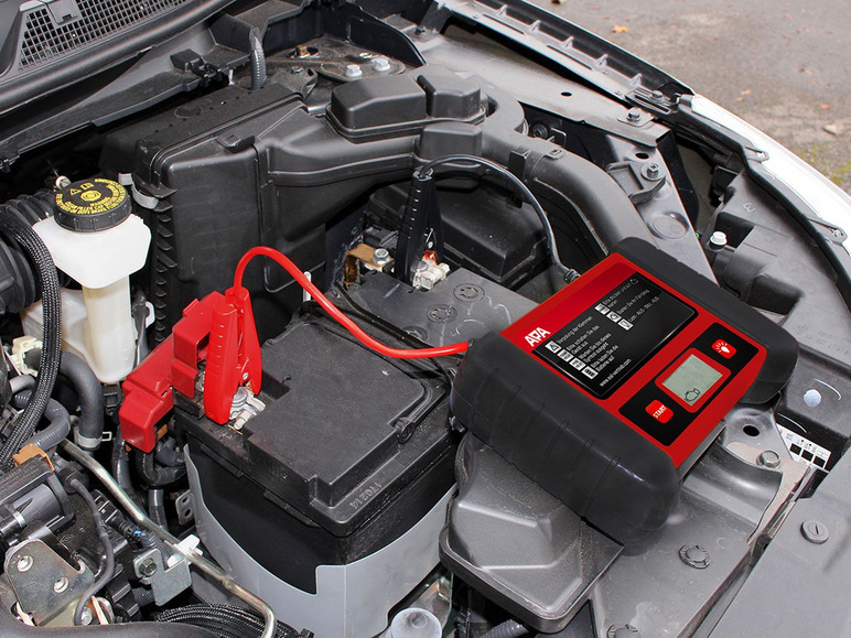 Ein rotes ARA Batterieladegerät wird verwendet, um eine Autobatterie zu testen.