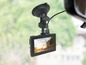 Eine Dashcam, die an der Windschutzscheibe eines Autos befestigt ist und einen LKW auf der Straße filmt