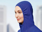 Eine Frau trägt eine blaue Jacke mit Kapuze.
