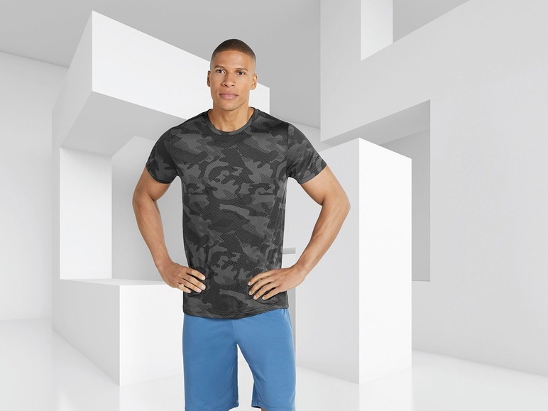Mann in einem Camouflage-T-Shirt und blauen Shorts