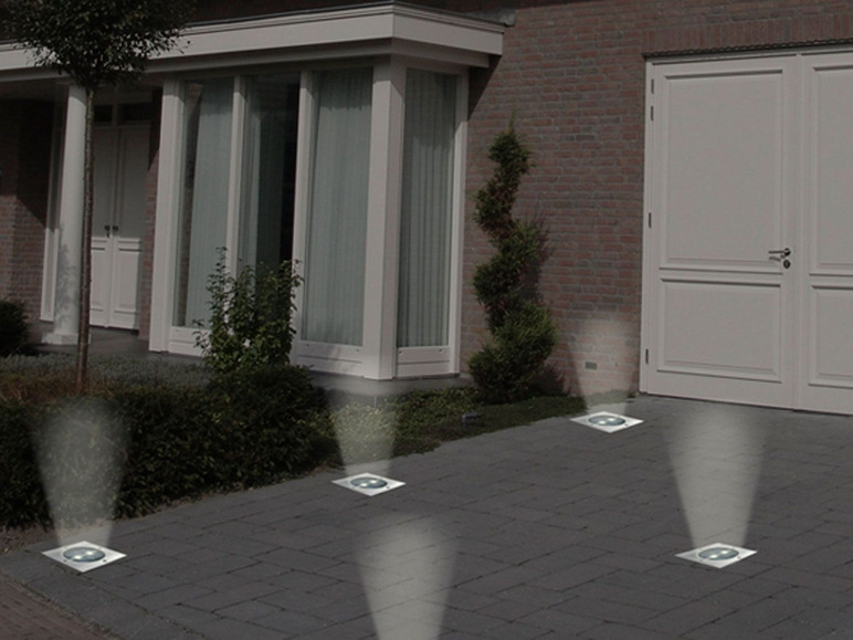 Vier runde LED-Bodenleuchten für Außenbeleuchtung.