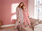 Eine Frau und ein Mädchen tragen rosafarbene Pyjamas mit Print