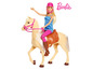 Barbie Puppe reitet auf einem Pferd.