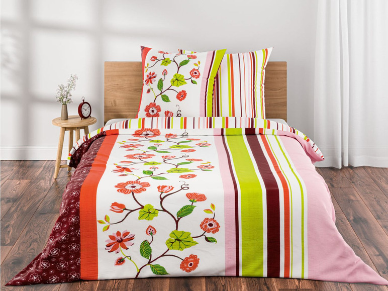 Ein weißer Bettbezug mit grünen Streifen und roten Blumen, inklusive Kissen.