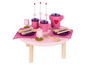 Ein rosafarbener Spieltisch mit Geschirr, Löffeln und einer Teekanne.