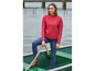 Eine Frau in einem roten Pullover und blauen Jeans steht in einem Boot.