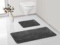 Zwei graue Badezimmerteppiche in einem Badezimmer.