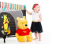 Ein Baby mit einem Winnie Puuh-Plüschtier und einem Winnie Puuh-Laufstall.