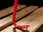 Ein roter Brecheisen auf Holzbrettern.