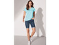 Frau in einem hellblauen T-Shirt und blauen Jeans-Shorts