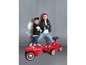 Zwei Kinder mit einem roten Big Bobby Car und Anhänger.