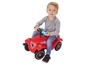Ein Kind fährt auf einem roten Big-Auto.