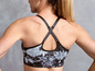 Frau mit einem schwarzen Sport-BH mit Tie-Dye-Muster.