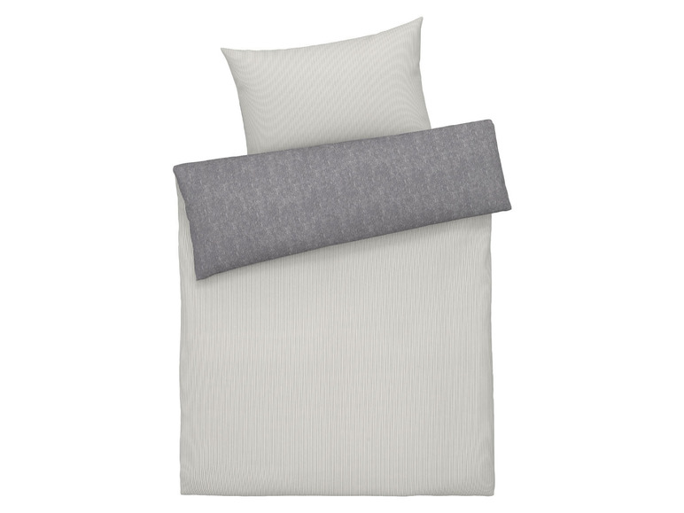 Ein weiß gestreiftes Bettbezug mit einem grauen Kissenbezug.