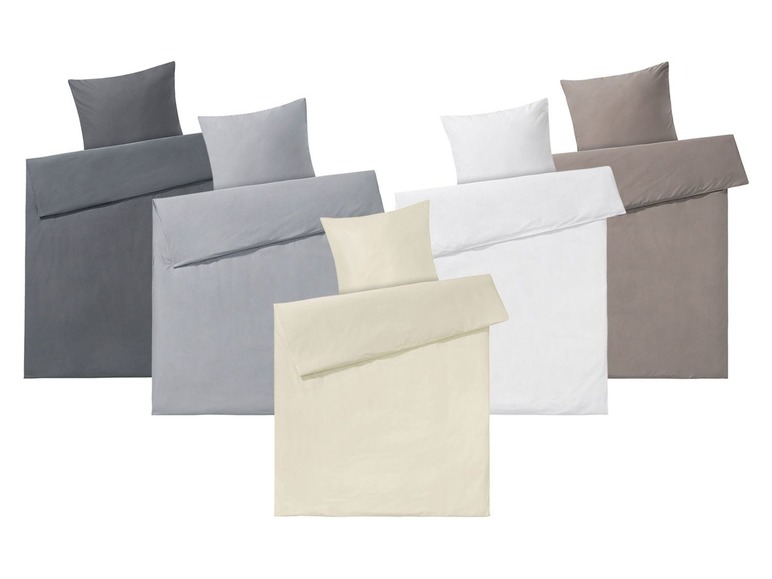 Verschiedene Bettwäsche-Sets in Grau-, Weiß- und Beigetönen.