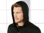 Ein Mann trägt einen schwarzen Kapuzenpullover.