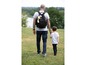 Ein Mann und sein Sohn gehen mit einem Rucksack mit Wickeltasche.