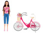 Eine Barbie-Puppe mit einem rosafarbenen Fahrrad und einem Blumenkorb.