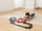 Ein Kind spielt mit einer Hot Wheels Rennbahn mit Schleife und Rampe.