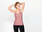 Frau in rosa Tanktop und schwarzen Leggings zum Sport.