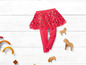 Rosa Leggings mit Glitzerrock und hölzernen Spielzeugpferden.