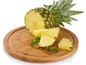 Eine Ananas, in Scheiben geschnitten, auf einem Holzbrett.