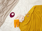 Gelbe Decke, Babykleidung mit Blumenmuster und Spielzeug.