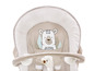Ein beiger Baby-Schaukelstuhl mit einem Bären-Motiv und Spielzeug.